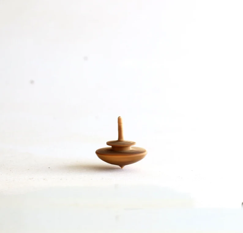 Tiny olive wood spinning tops